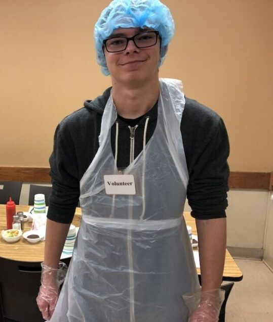 Shelter KC Volunteer posing in front of dining room table