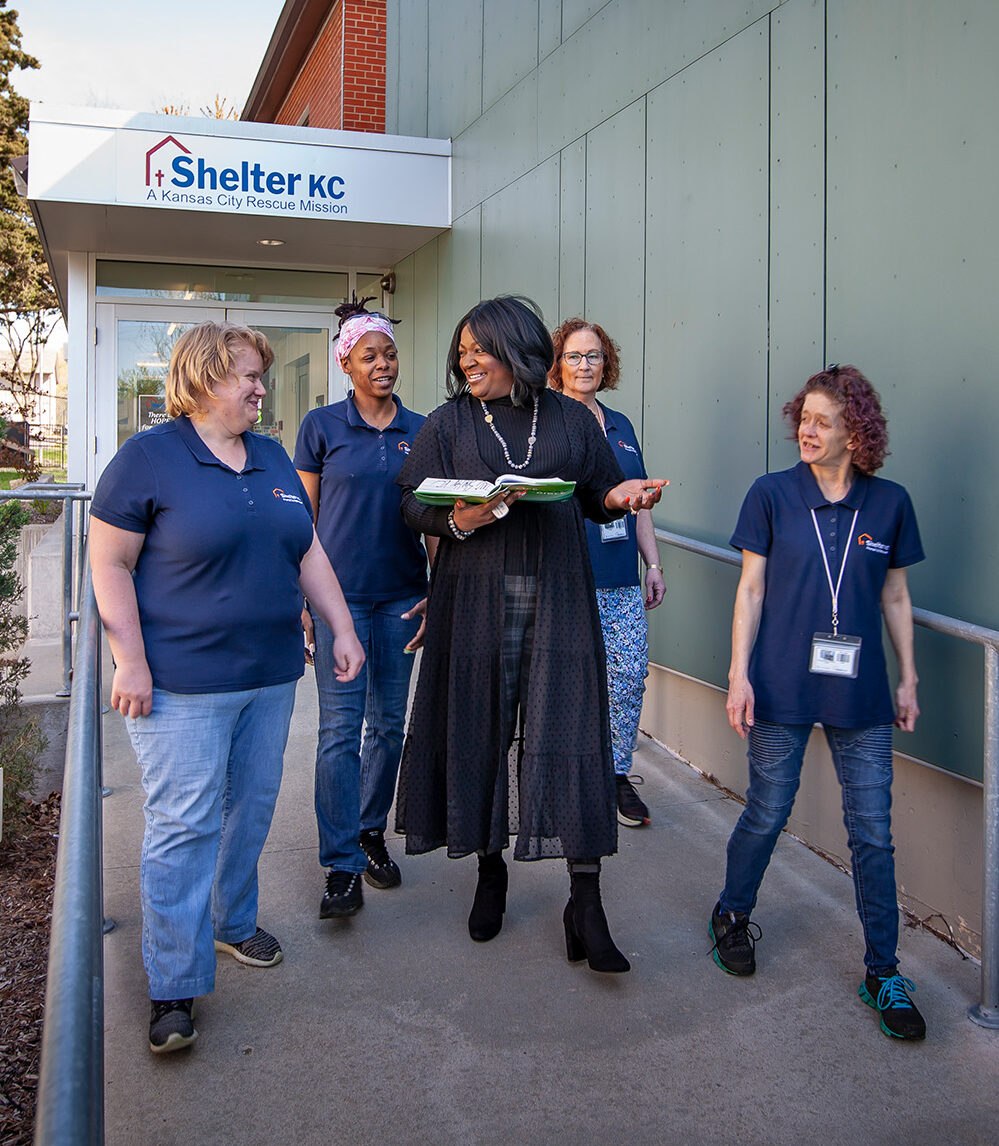 Women from the Shelter KC Women's ministry walk outside while reading bible